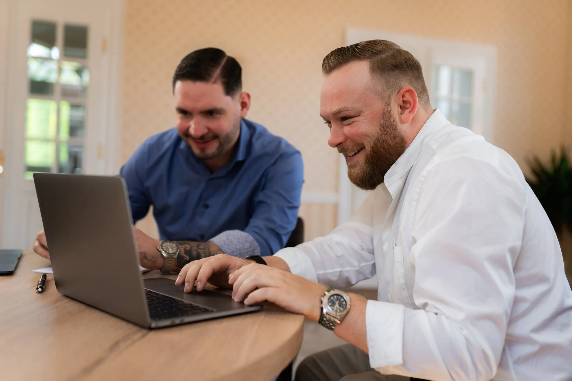 Dennis und Lucas arbeiten gemeinsam am Laptop.